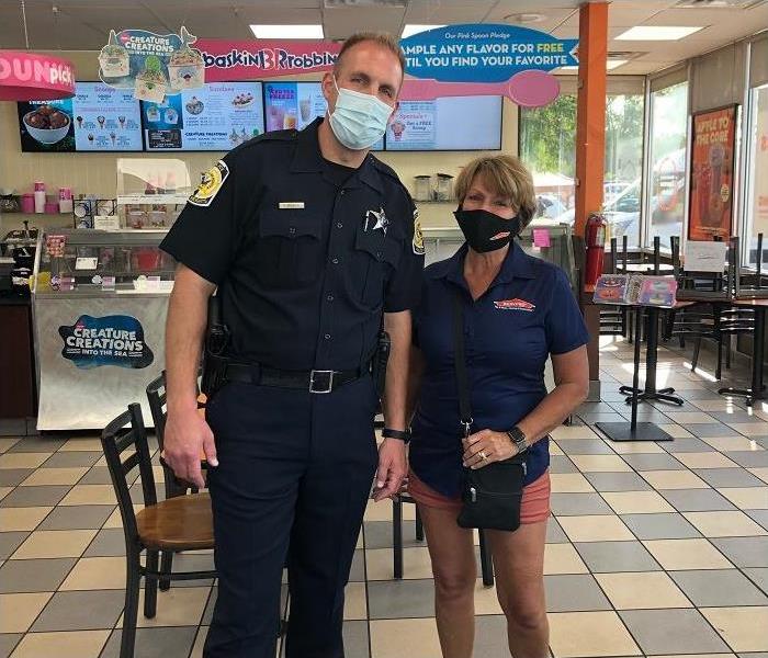 Police officer and woman posing inside Baskin Robbins