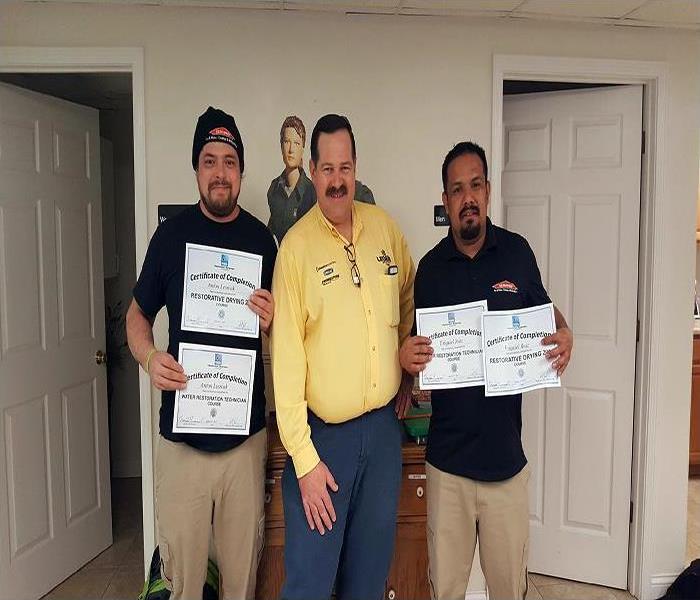 SERVPRO employees holding water training certificates  