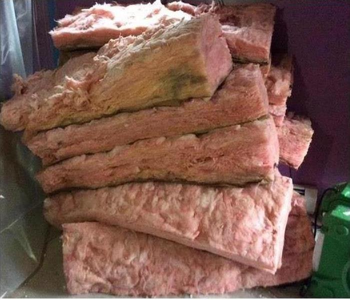 Mold damaged insulation stacked on the floor 