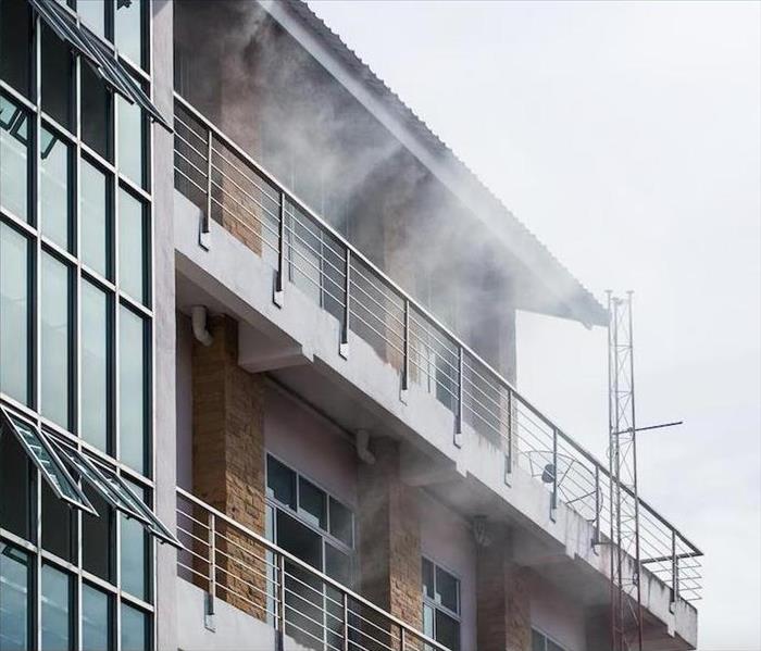 Smoke billowing out of a window. 