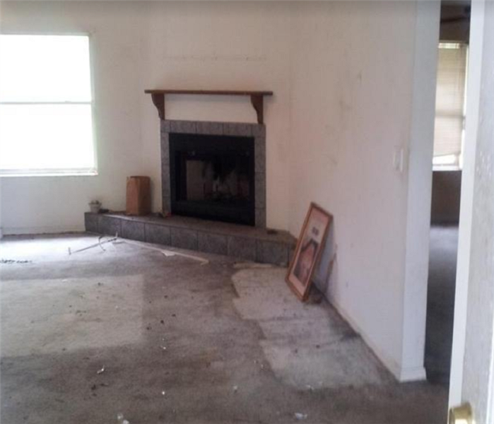water on floor in empty living room; fire place