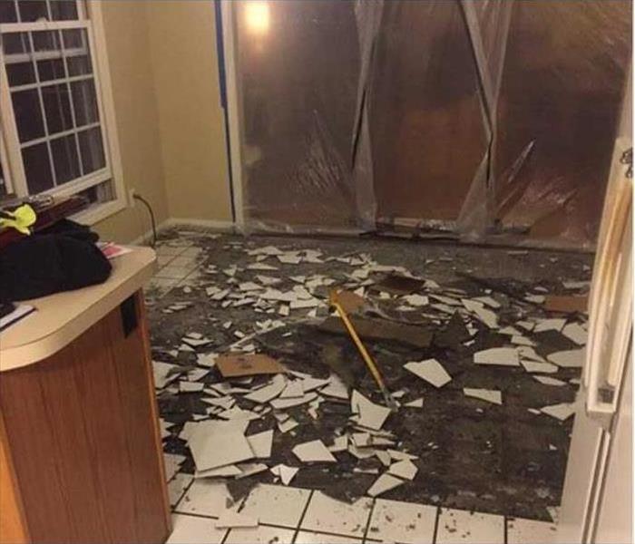 A room with the tile floor lifted up from storm damage