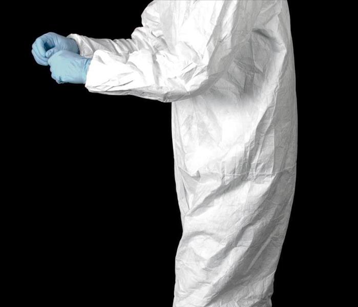 Person in a white suit with blue gloves 