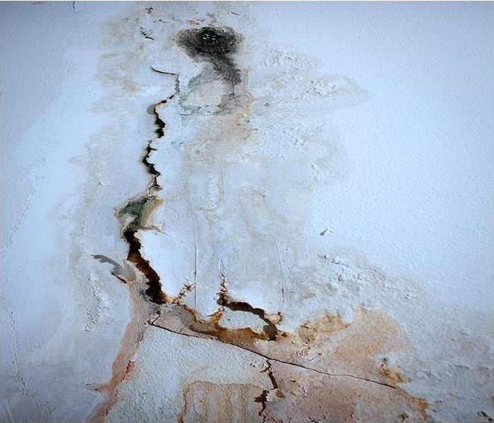 water damage causing peeling paint on wall